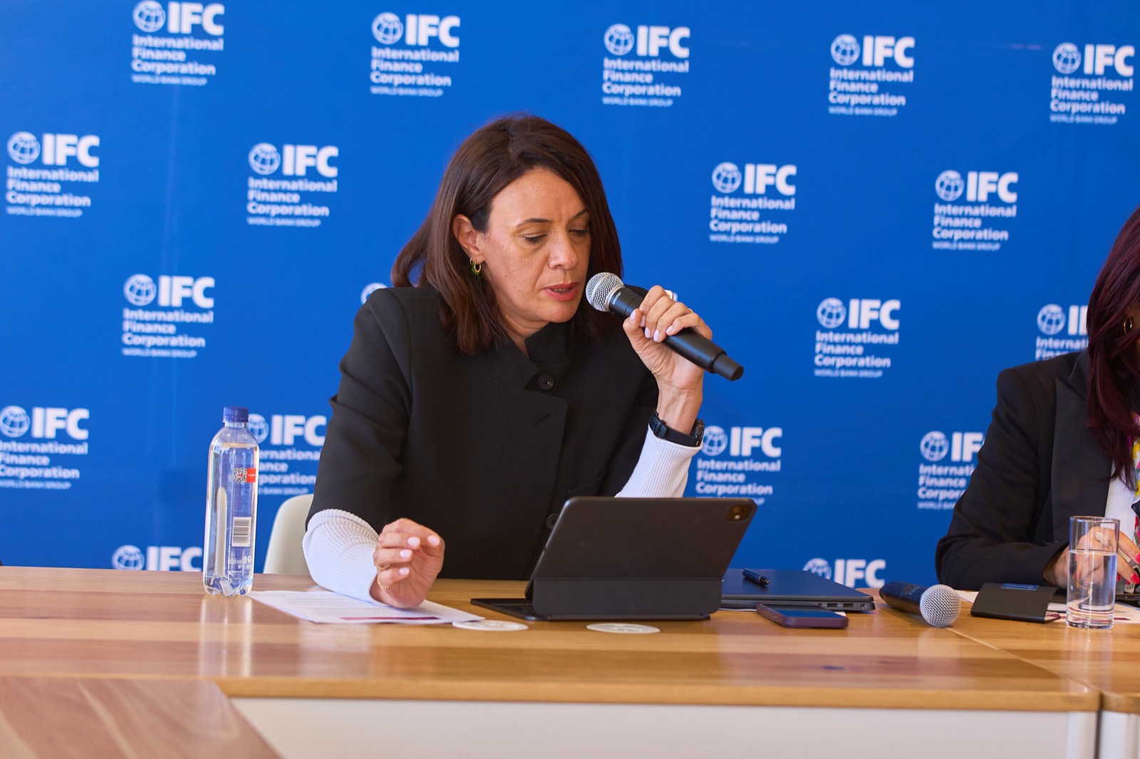 A speaker addressing the room into a microphone at the IFC event