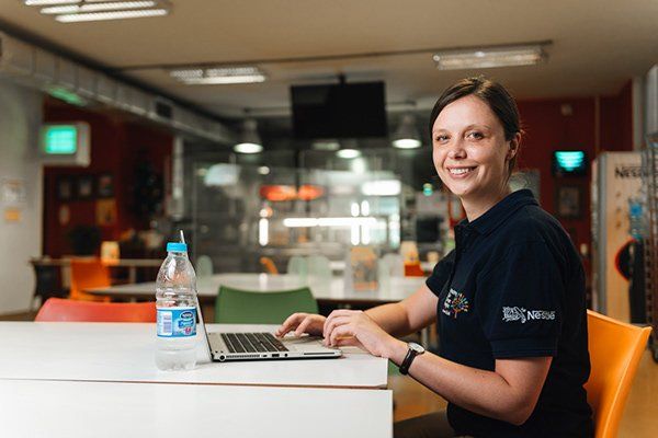 A Nestlé employee at a laptop in the factory canteen