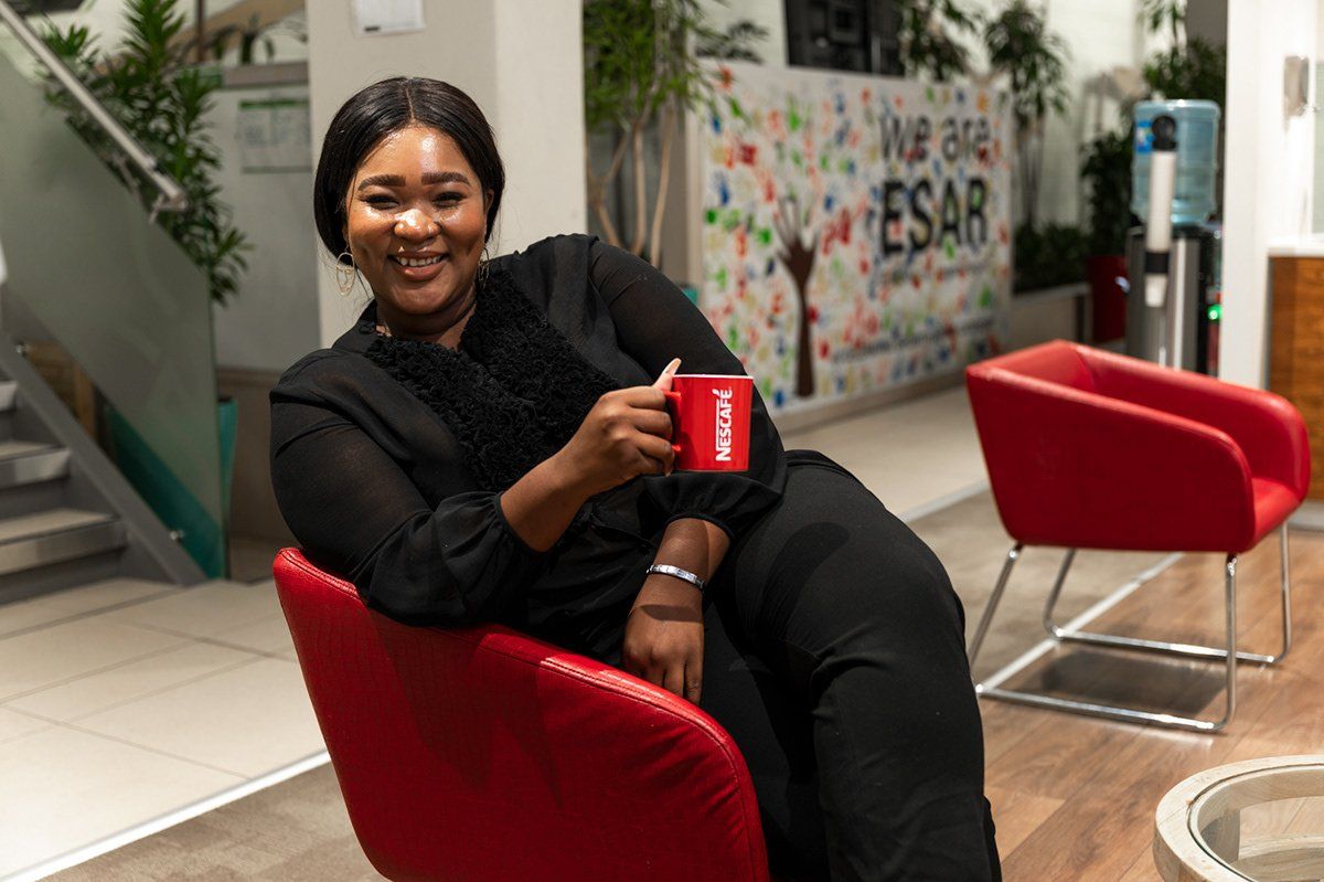 A Nestlé employee seated with a coffee, filmed for the campaign
