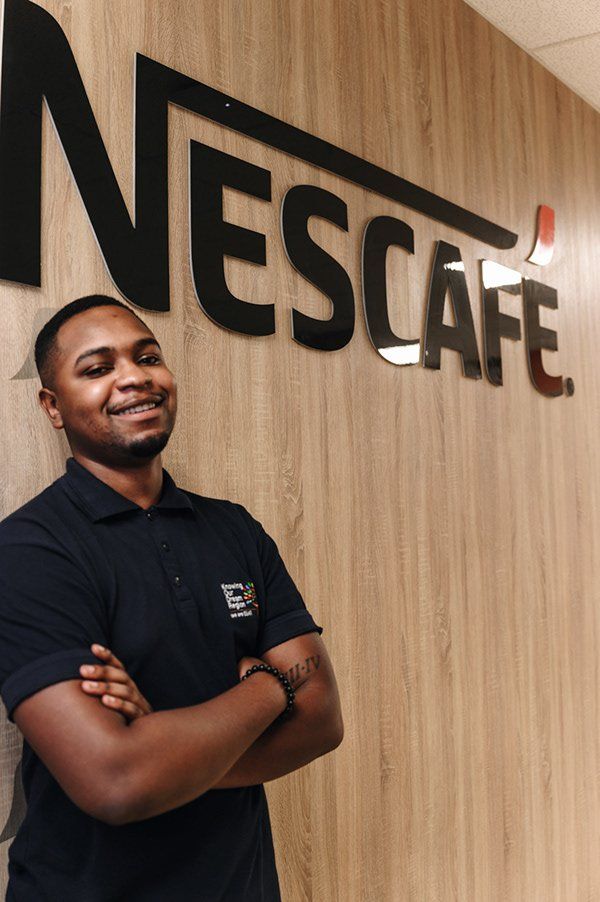 A Nestlé employee beside the Nescafé wall